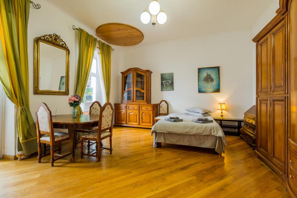 布拉索夫科龙豪斯民宿的一间卧室配有桌子、床和桌椅