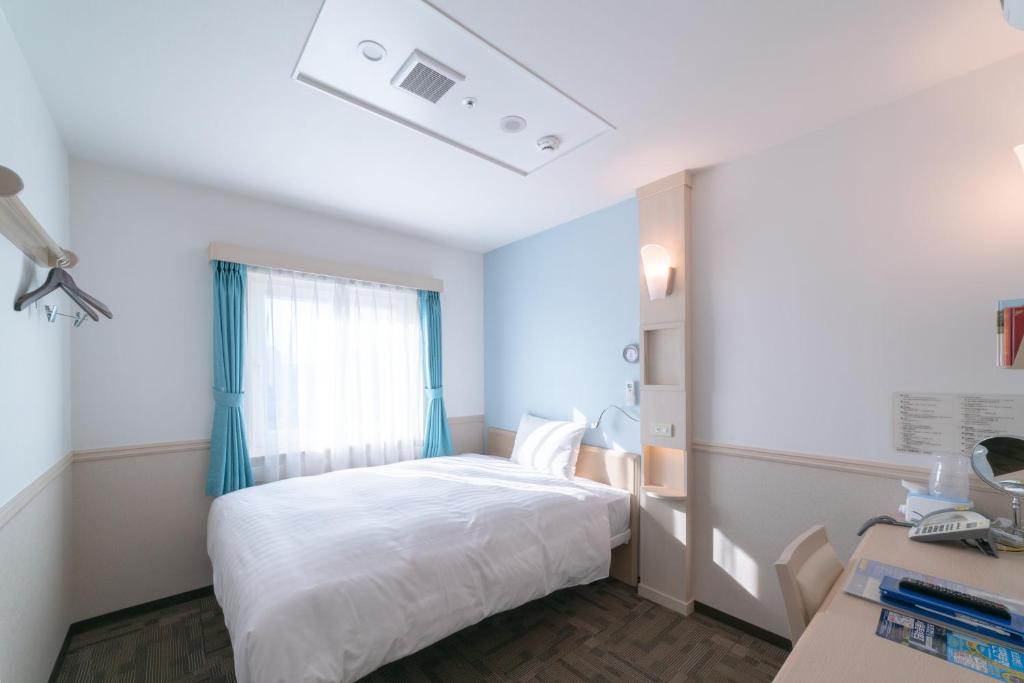 大邱Toyoko Inn Daegu Dongseongro的卧室配有白色的床和窗户。