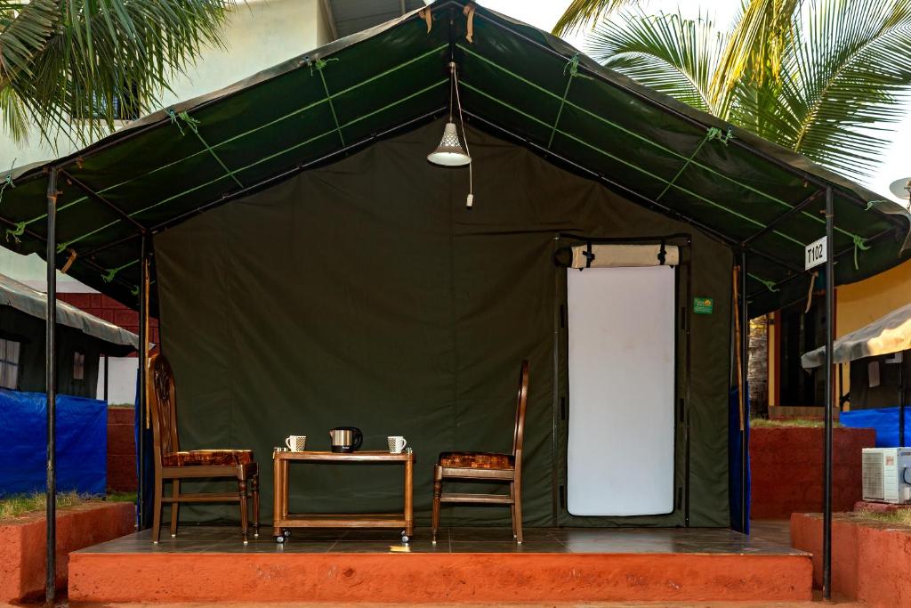 达博利Tent-O-Treat Premium Rooms near Dapoli的绿色帐篷 - 带2把椅子和1张桌子