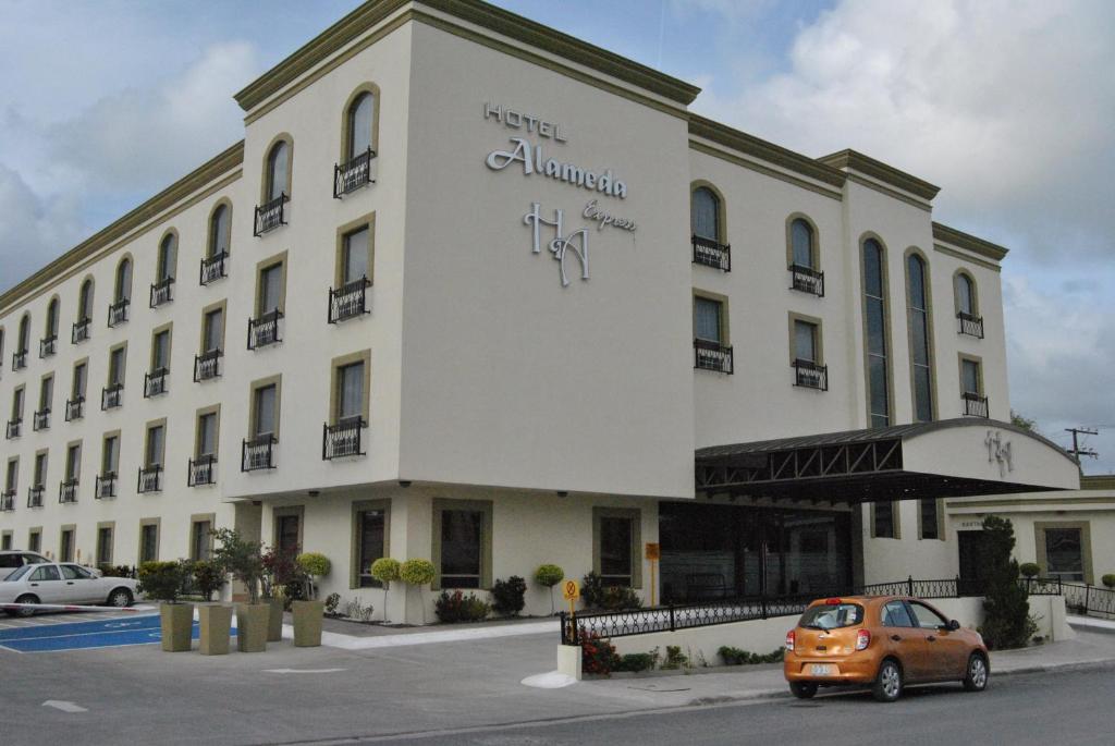 马塔莫罗斯阿拉米达快捷酒店的停在大楼前的橙色汽车