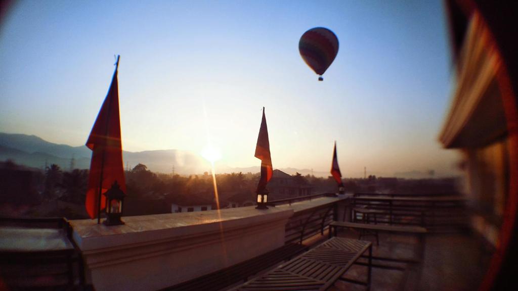 万荣SD View Hotel的飞过有旗帜的建筑物的热气球