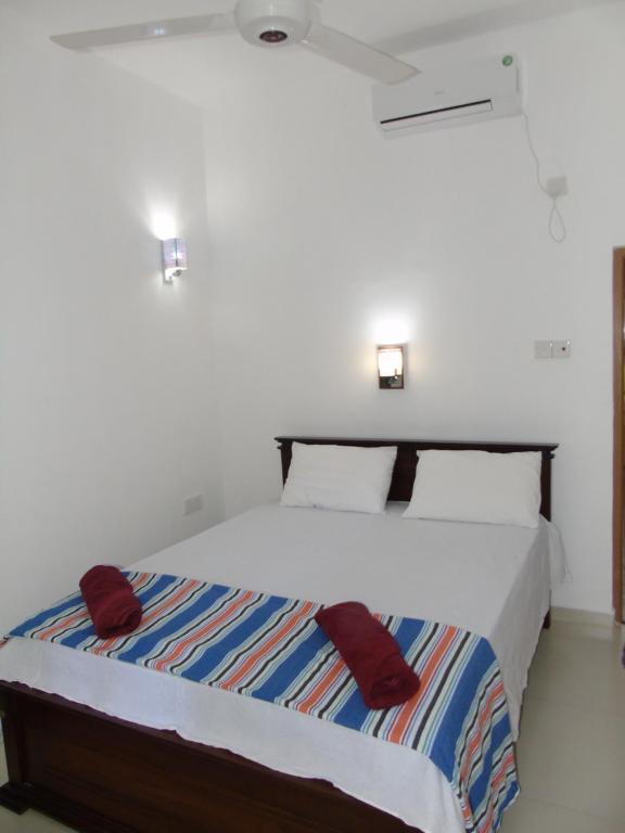 代尼耶耶Eco Villa - Sinharaja的一间卧室配有一张带红色枕头的大床