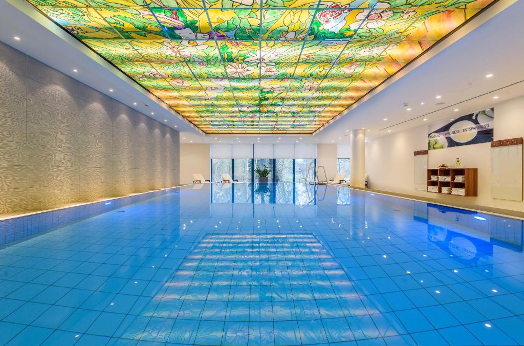不莱梅玛丽蒂姆不来梅酒店的一个带色彩缤纷的天花板的游泳池和一个游泳池