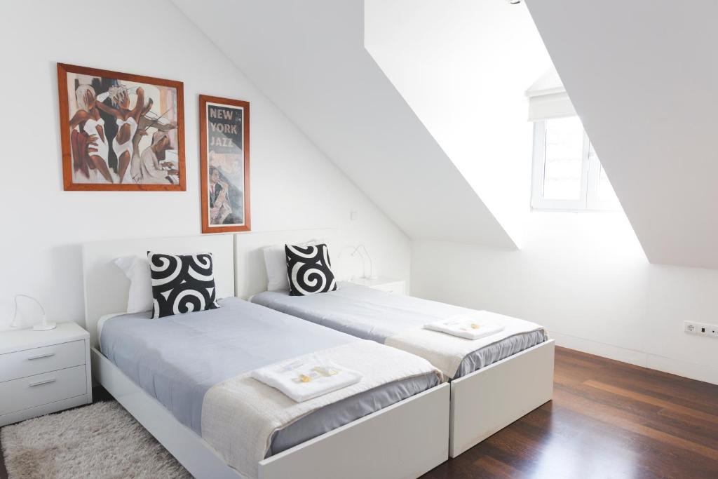 波尔图APOSENTUS - Downtown Porto Modern Penthouse的一间白色卧室,配有两张床和窗户