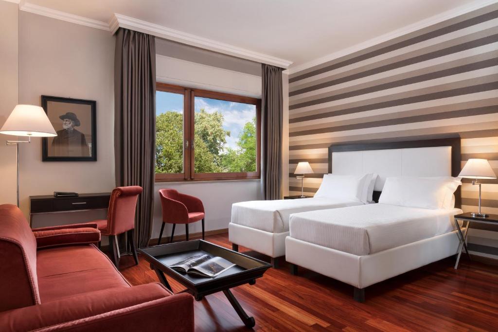 帕尔马新浪玛丽亚路吉亚酒店的酒店客房配有床、沙发和桌子。