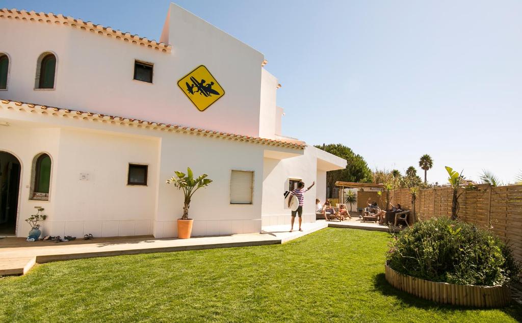 萨格里什Algarve Surf Hostel - Sagres的站在房子院子中的人