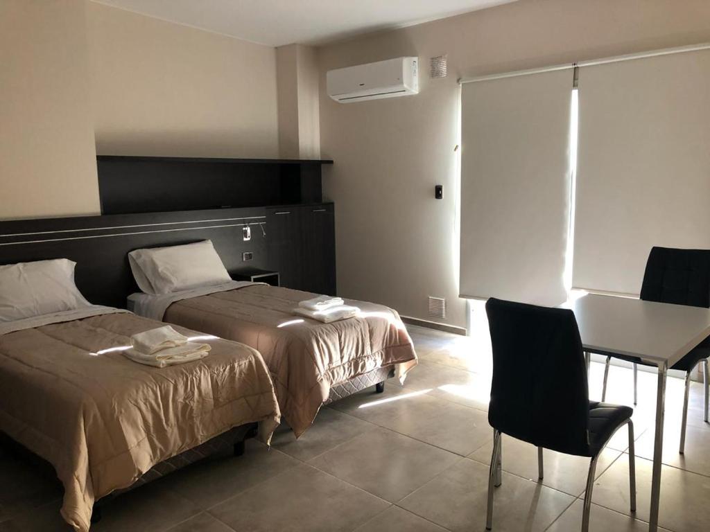 圣胡安Complejo Edificio Rosario的一间卧室配有两张床、一张桌子和一张书桌