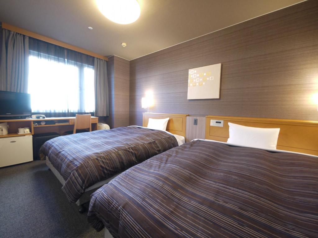 小牧市格兰蒂亚小牧路线酒店的酒店客房设有两张床和电视。