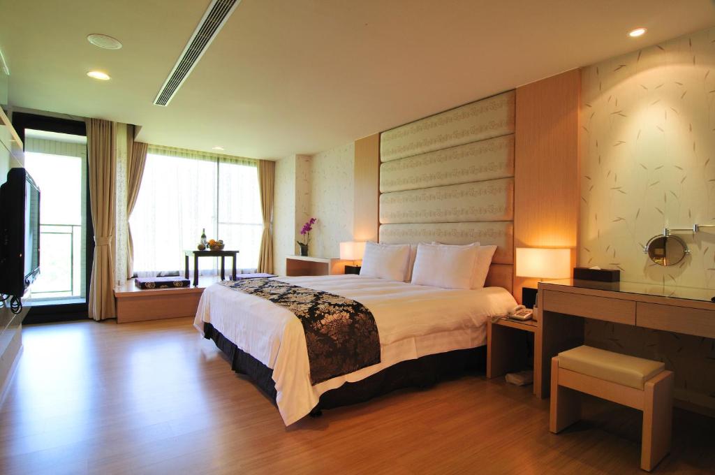 埔里楓樺台一渡假村(台一生態休閒農場)的一间设有大床和窗户的酒店客房