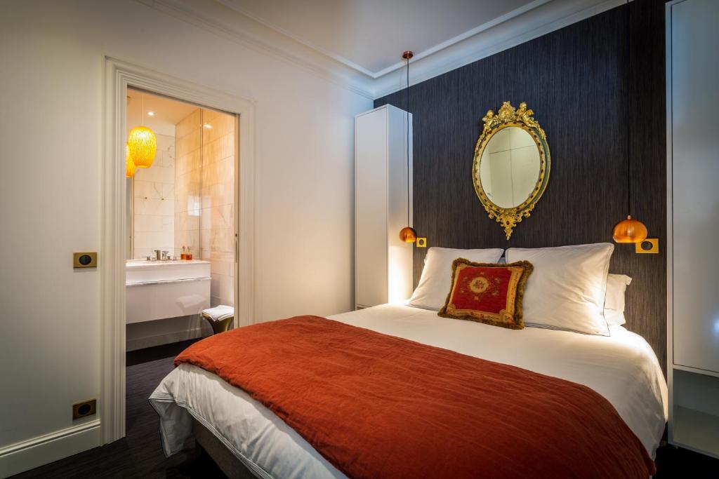 梅斯L'Appartement des Roches的一间卧室配有一张带镜子的床和一间浴室