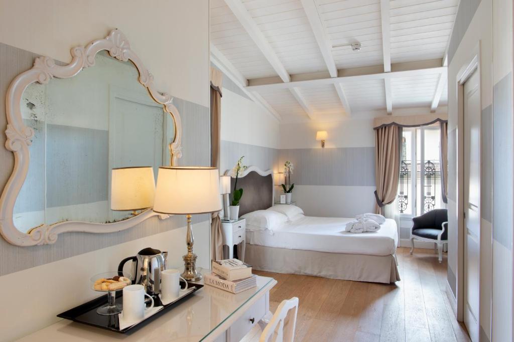 佛罗伦萨拉帕洛酒店的酒店客房,配有床和镜子