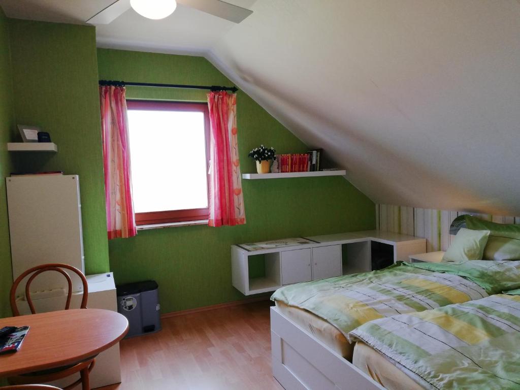 皮尔纳Privatzimmer mit Aussicht的一间卧室配有一张床、一张桌子和一个窗户。
