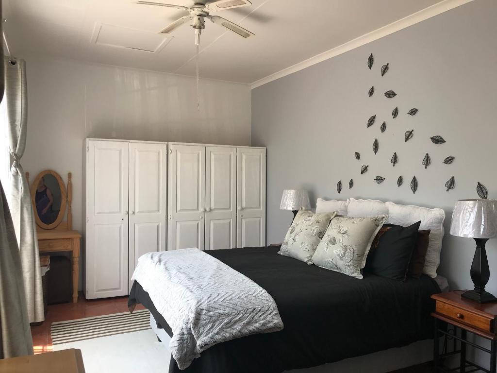 伯诺尼Contemporary Stay at Giraffe Cottage的一间卧室配有一张带黑色棉被的床