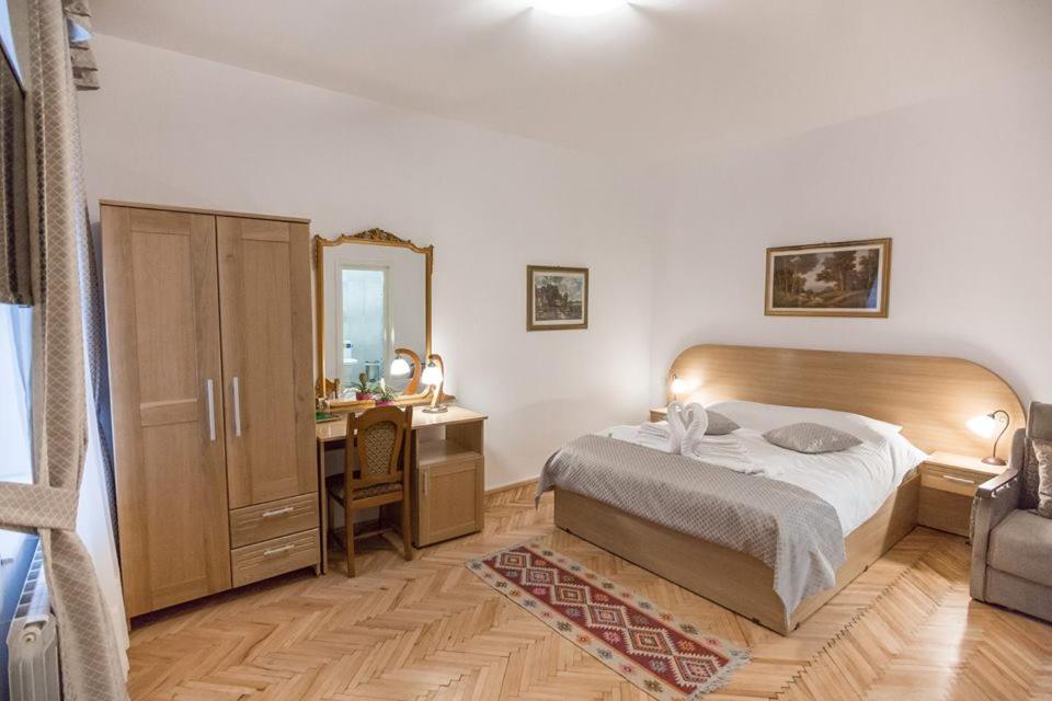 密古雷休治Pensiunea San Gennaro的一间卧室配有一张床、一张书桌和一面镜子