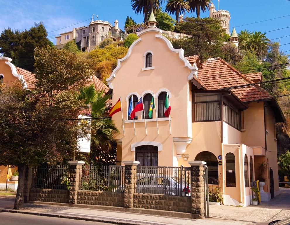 维纳德马Aquamarina Apart Hotel的粉红色的房子,上面有旗帜