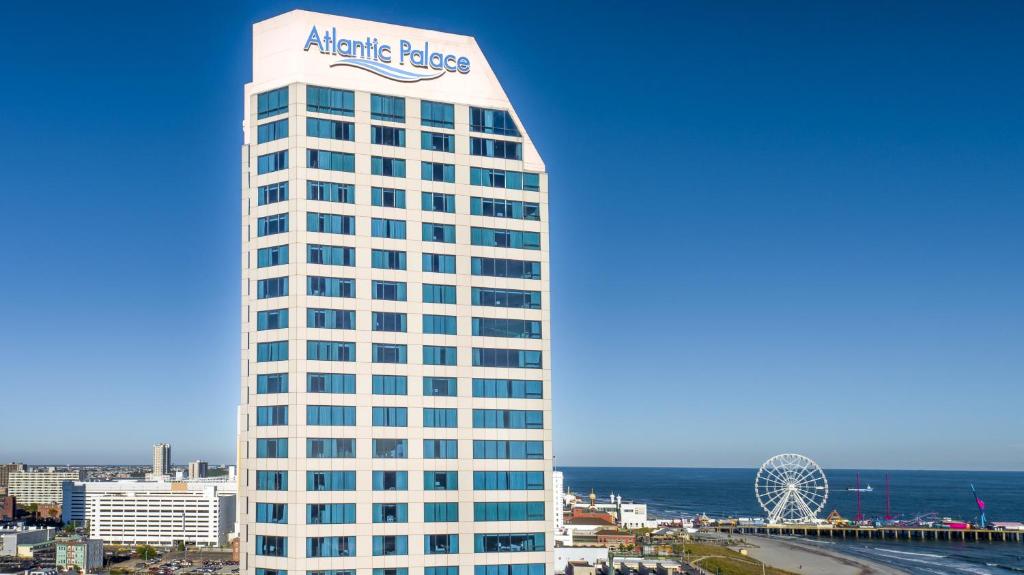 大西洋城Boardwalk Resorts at Atlantic Palace的一座高大的白色建筑,上面有大西洋宫殿的标志