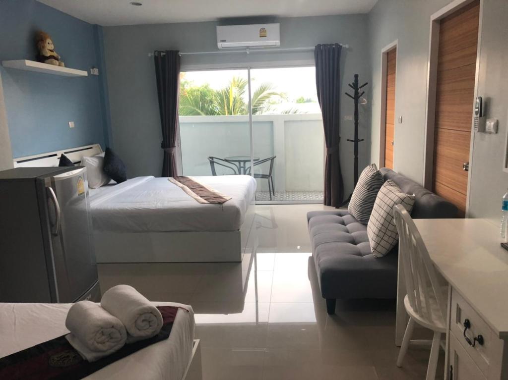 奈扬海滩Khao Oat airport的一间带两张床的卧室和一间带沙发的客厅