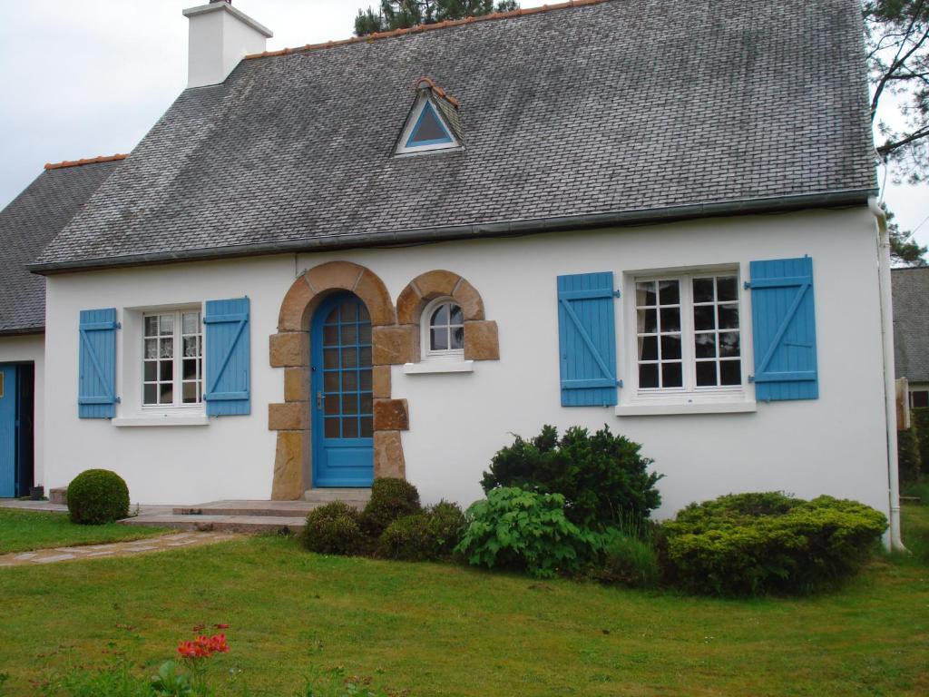 佩罗斯-吉雷克moulin de la lande的白色的房子,有蓝色百叶窗和灰色的屋顶
