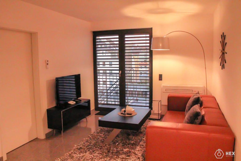 杜塞尔多夫蓝石公寓式酒店的客厅配有红色沙发和电视