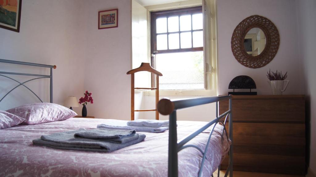 辛特拉Family house Adraga的一间卧室配有一张带镜子和梳妆台的床