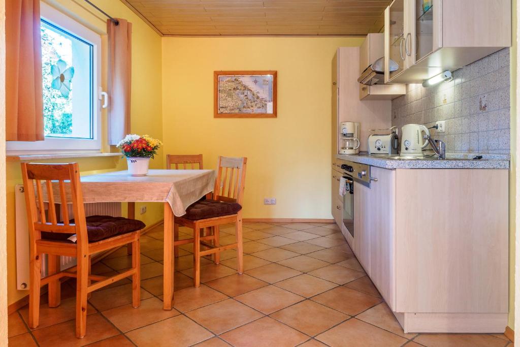 特拉森海德Gartenhaus im Ostseebad Trassenheide的一间厨房,里面配有桌椅