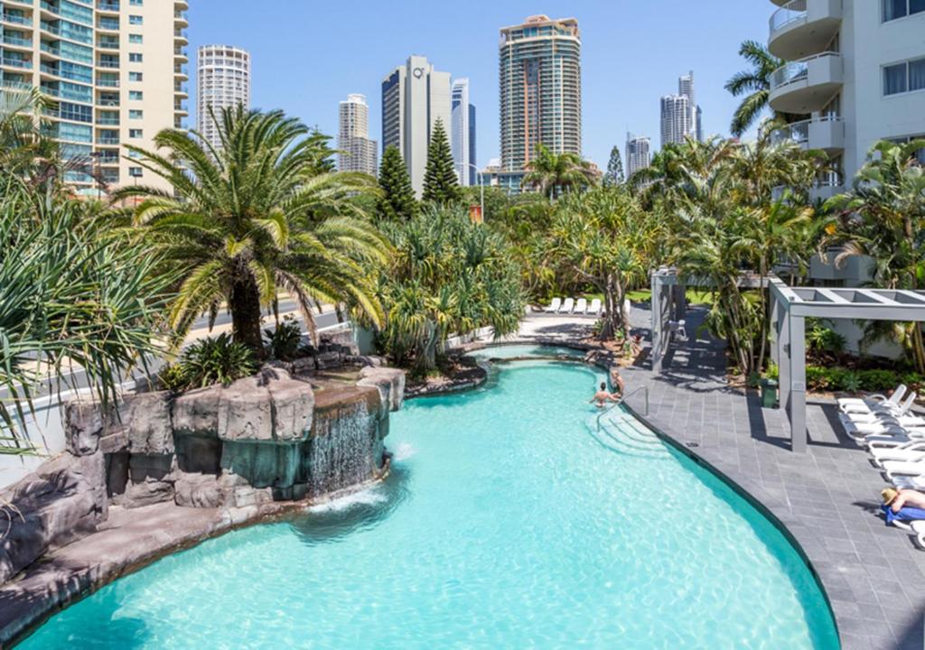 黄金海岸Sovereign on the Gold Coast的棕榈树和建筑度假村的游泳池