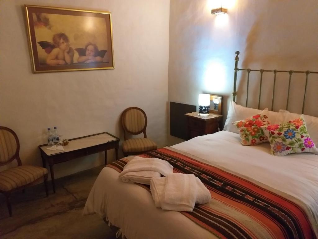 普尔马马尔卡Sendero De Las Cabras的一间卧室配有一张床和一张桌子及椅子