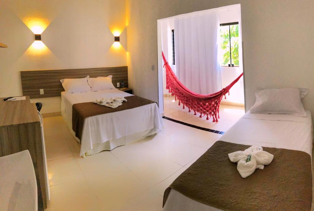 马拉戈日Pousada Paraíso Maragogi的酒店客房设有两张床和窗户。