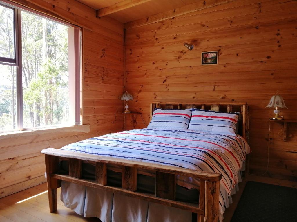 谢菲尔德Minnow cabins Lower Beulah的小木屋内一间卧室,配有一张床