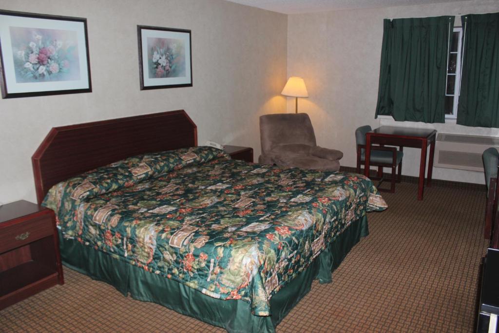 加登城花园城旅馆的配有一张床和一把椅子的酒店客房