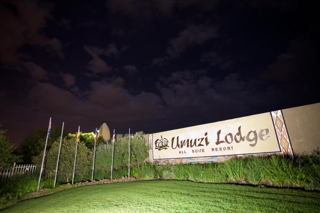 塞昆达Umuzi Lodge的夜间在田野里看不见的小屋的标志