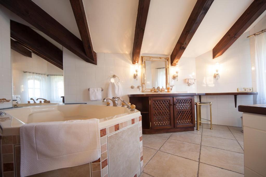 安德希斯罗曼蒂克别墅酒店的大型浴室设有水槽和浴缸。