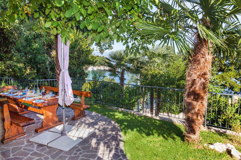 洛夫兰Apartment Villa Lidija的一张带雨伞的野餐桌,享有水景