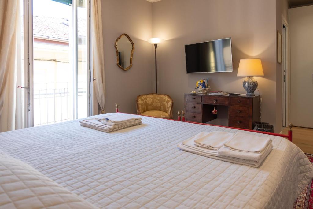维罗纳La Nuova Corte Rooms的卧室配有白色床和毛巾