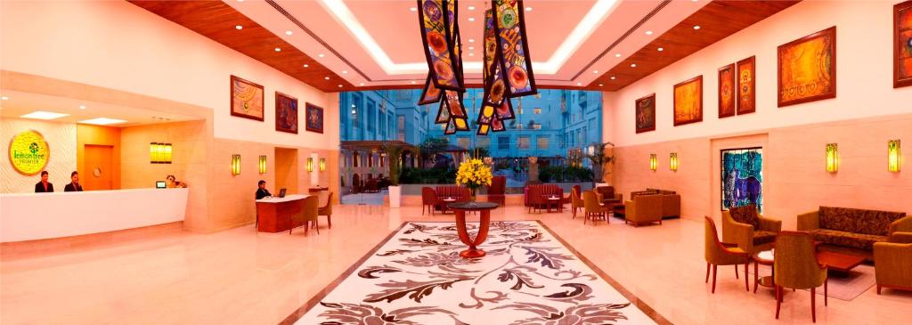 新德里德里机场柠檬树酒店的医院的大厅,有椅子和桌子