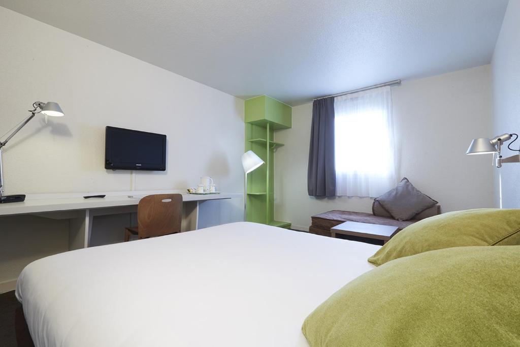 勒布朗-梅尼尔布朗梅尼尔钟楼酒店的酒店客房配有一张床、一张书桌和一台电视。