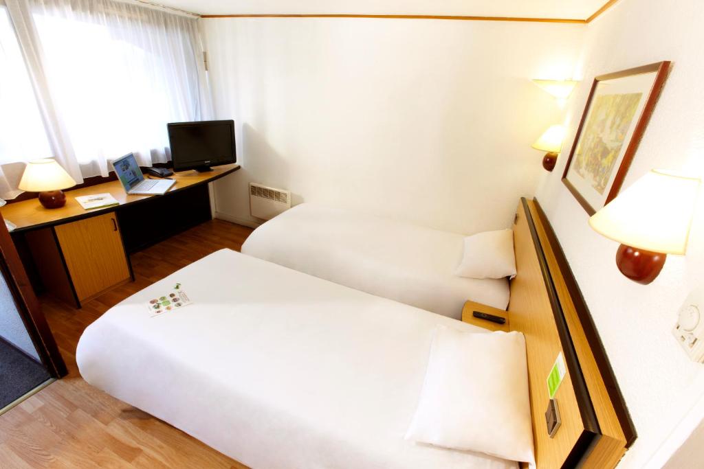 勒布朗-梅尼尔勒布朗-梅尼尔基里亚德酒店的酒店客房配有两张床和一张书桌