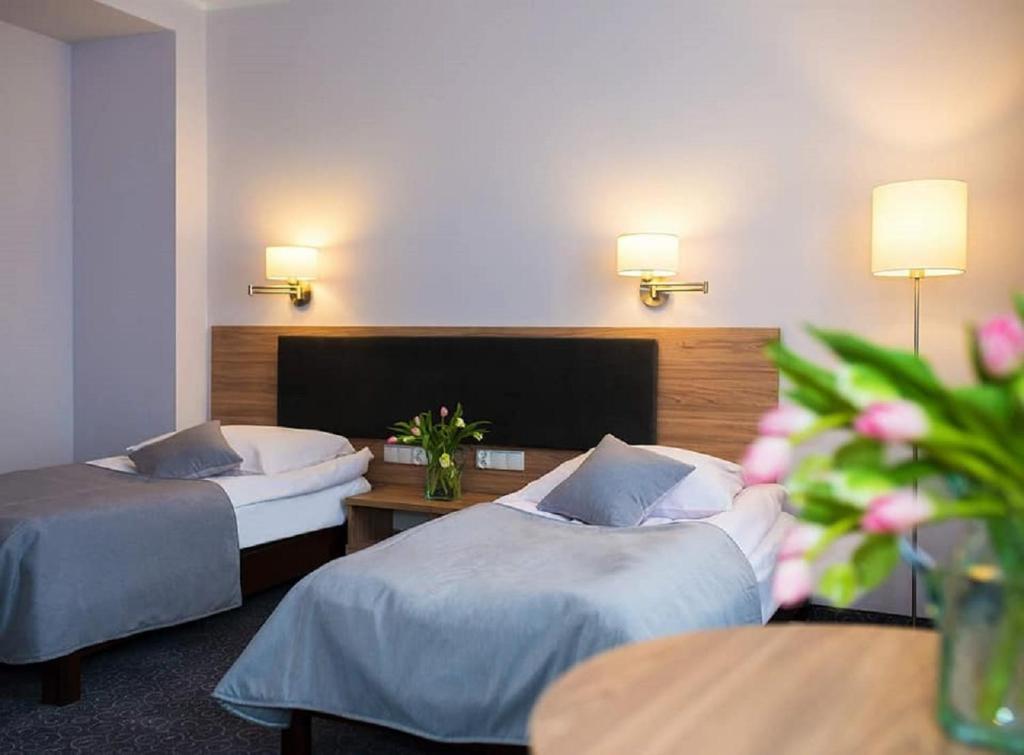 科沙林格罗马达酒店的酒店客房,设有两张床和一张鲜花桌。