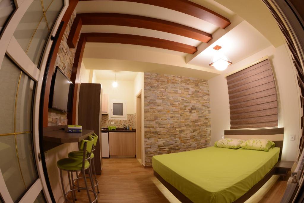 卜舍里包豪斯小木屋公寓的一间卧室设有绿色的床和砖墙