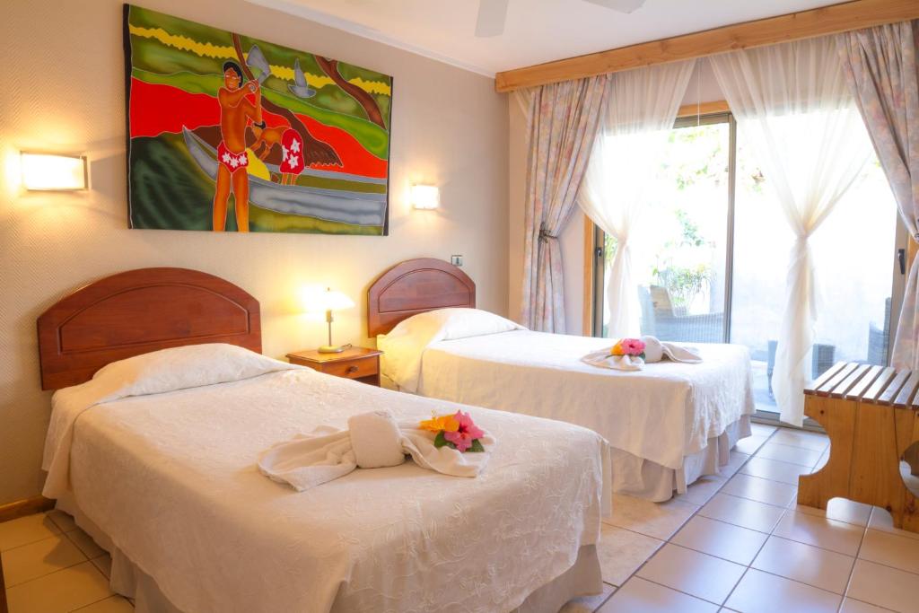 安加罗阿奥泰酒店的酒店客房设有两张床和大窗户。