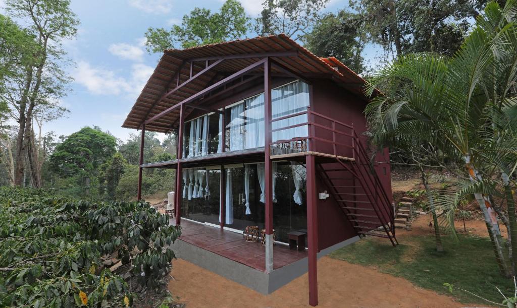 马迪凯里Itsy By Treebo - Jammabane Cottage With Mountain View的一间红色的房子,设有玻璃窗和屋顶