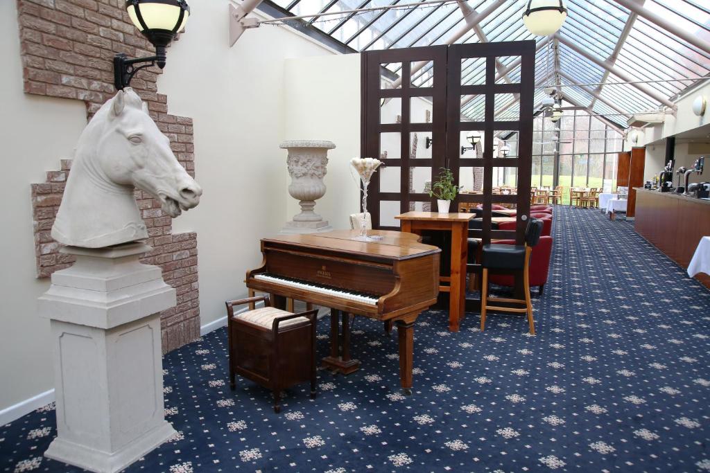 科尔维尔隐居公园酒店的墙上有一架钢琴和一匹马的房间