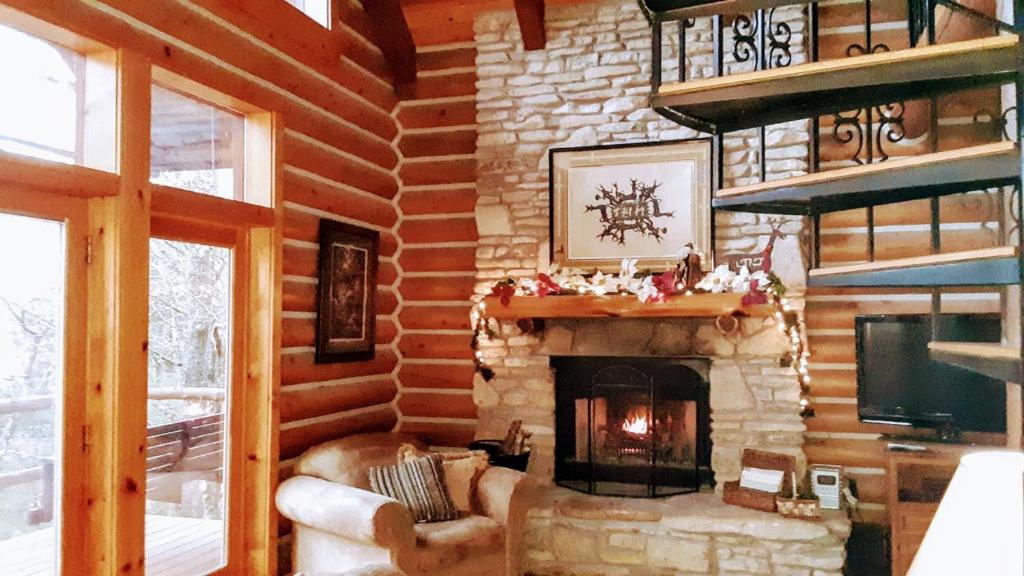 尤里卡斯普林斯Cherokee Mountain log Cabins的小木屋内带壁炉的客厅