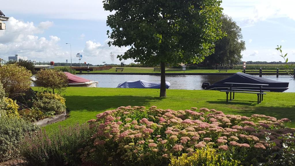 WeteringVakantiehuis de wilgenhof的水上公园,设有野餐桌和小船
