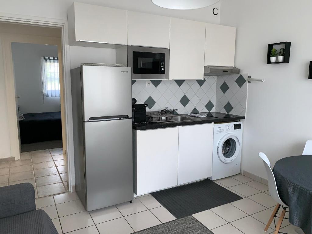 鲁瓦扬Appartement des Tilleuls RDC的厨房配有冰箱和洗衣机。