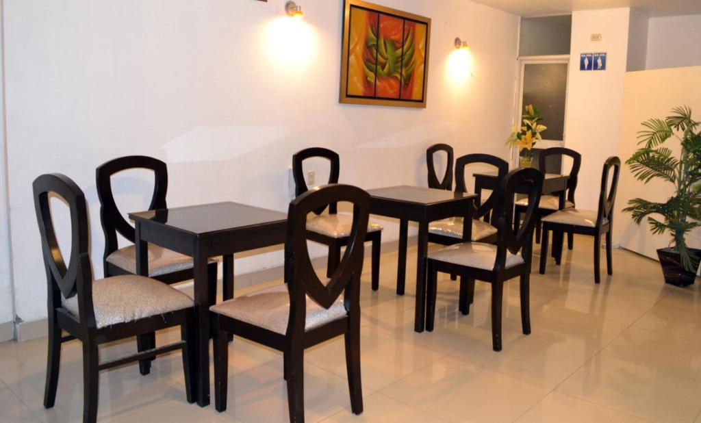 齐克拉约Hotel Casa de Turistas的一组桌子和椅子在等候室里
