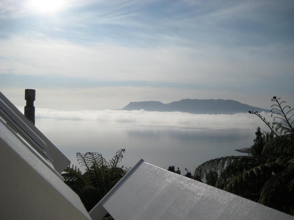 Lake Tarawerate Whare -Lake Tarawera tree-top nest的天空中云层的海洋景