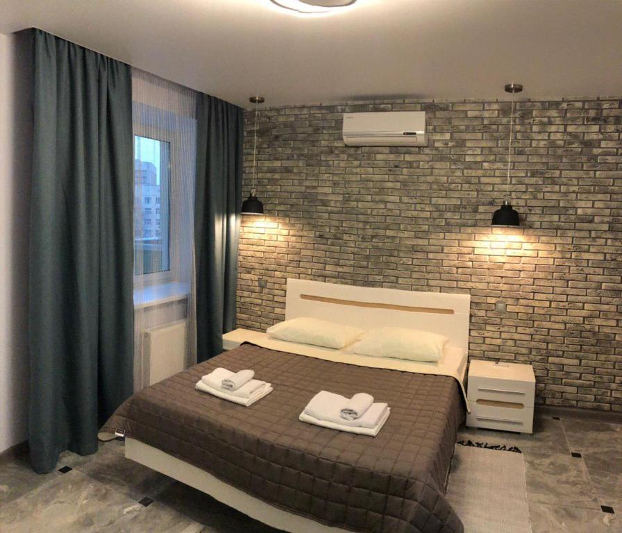 基辅Апартаменти Герцена 35的一间卧室设有一张床和砖墙