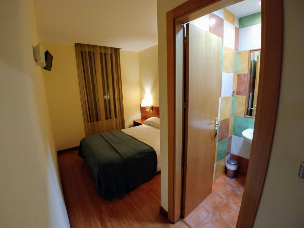 莱昂Hostal Prada Borges的小房间设有一张床和一间浴室