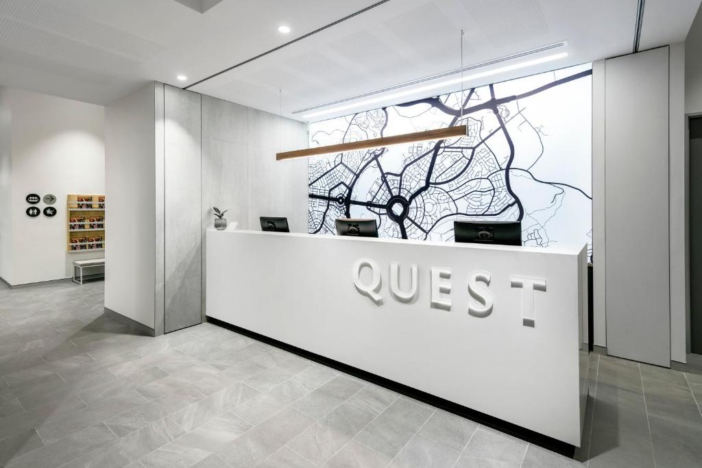 堪培拉Quest Canberra City Walk的大厅,柜台上有一个qsis标志